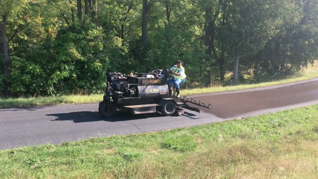 Using our ride on sealer application machine to finish long driveway